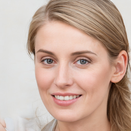 Joyful white young-adult female with long  brown hair and blue eyes