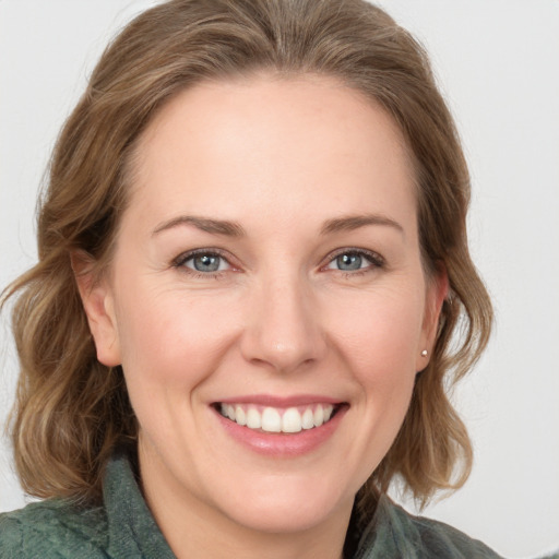 Joyful white adult female with medium  brown hair and grey eyes