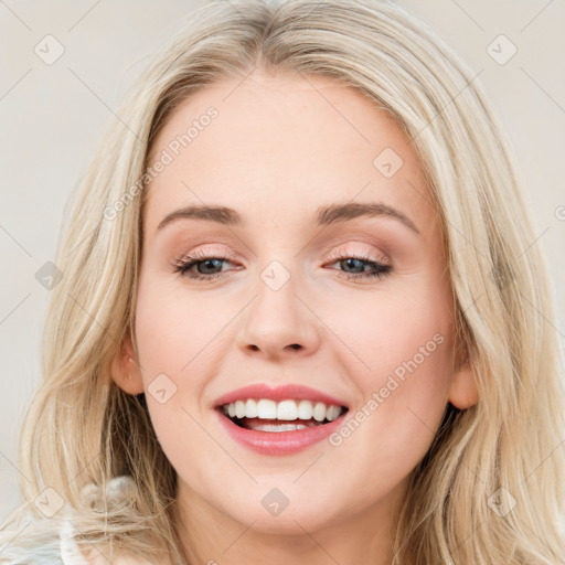 Joyful white young-adult female with long  brown hair and blue eyes