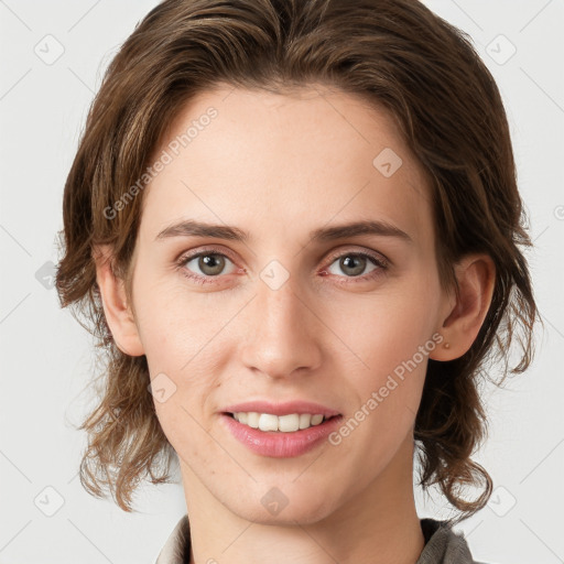 Joyful white young-adult female with medium  brown hair and grey eyes