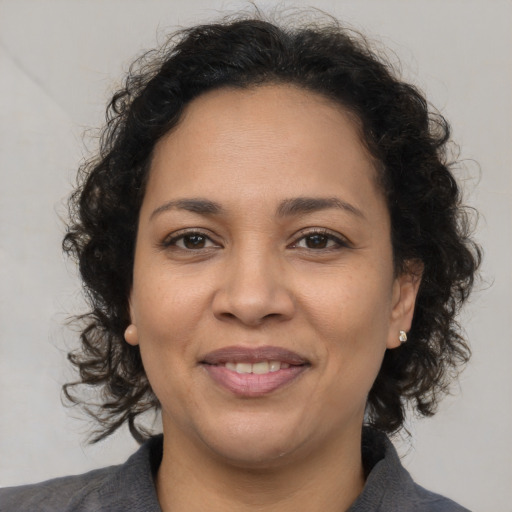 Joyful latino adult female with medium  brown hair and brown eyes