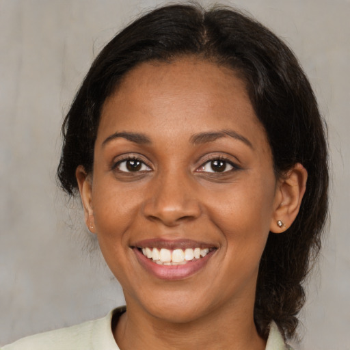 Joyful black young-adult female with medium  brown hair and brown eyes