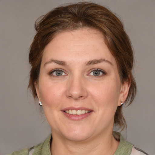 Joyful white adult female with medium  brown hair and grey eyes