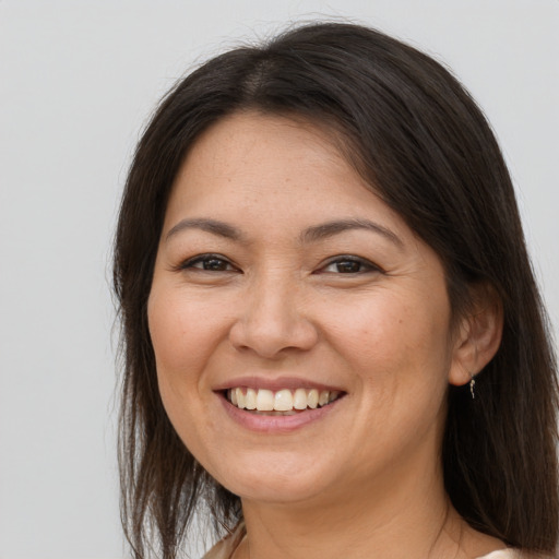 Joyful white adult female with long  brown hair and brown eyes