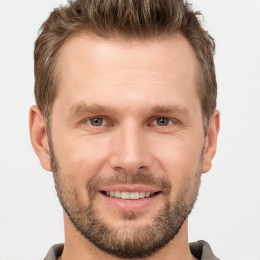 Joyful white adult male with short  brown hair and brown eyes