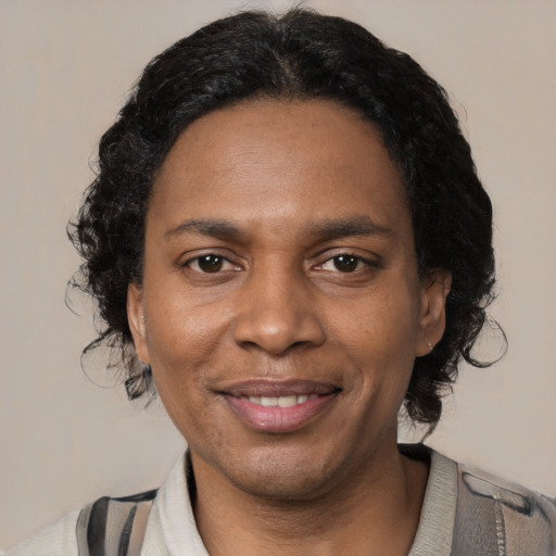 Joyful black adult female with medium  brown hair and brown eyes