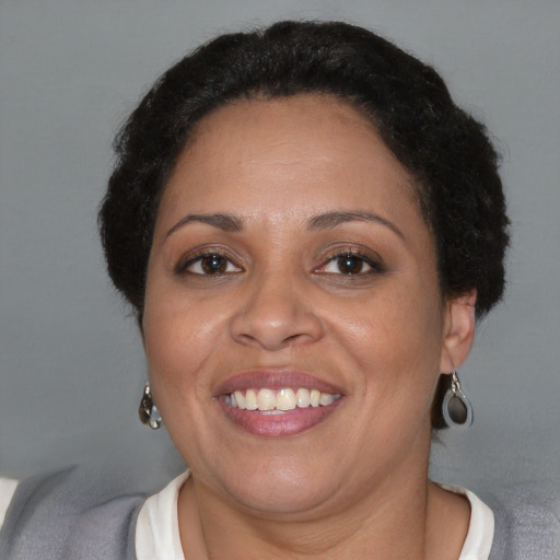 Joyful black adult female with short  brown hair and brown eyes