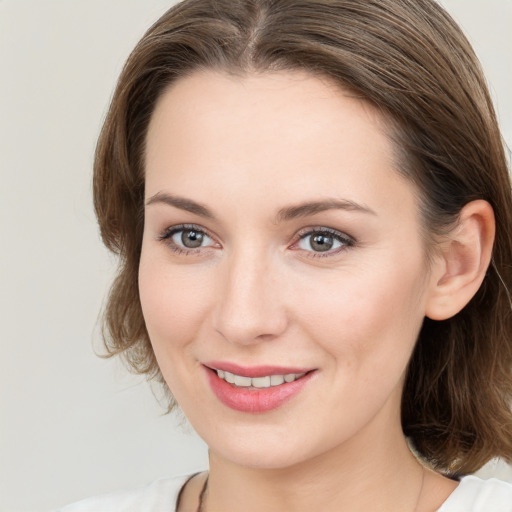 Joyful white young-adult female with medium  brown hair and grey eyes