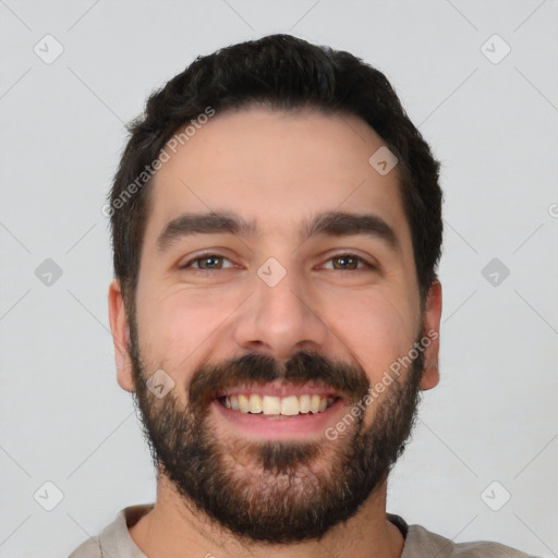 Joyful white young-adult male with short  black hair and brown eyes