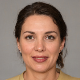 Joyful white adult female with medium  brown hair and brown eyes