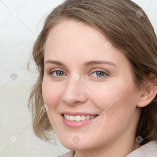 Joyful white young-adult female with medium  brown hair and blue eyes