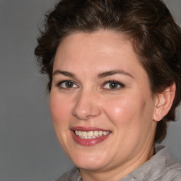 Joyful white adult female with medium  brown hair and brown eyes