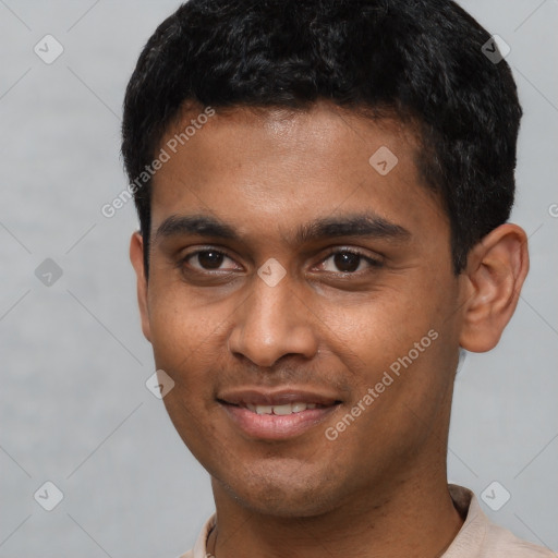 Joyful black young-adult male with short  brown hair and brown eyes