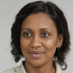 Joyful black adult female with medium  brown hair and brown eyes