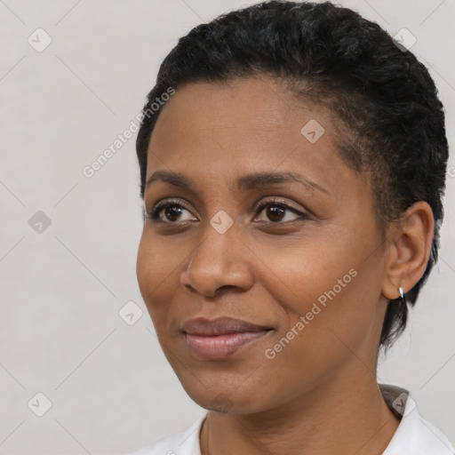 Joyful black young-adult female with short  black hair and brown eyes