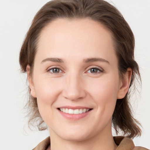 Joyful white young-adult female with medium  brown hair and grey eyes