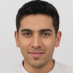 Joyful latino young-adult male with short  brown hair and brown eyes
