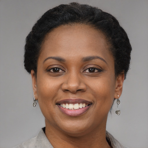 Joyful black adult female with short  black hair and brown eyes
