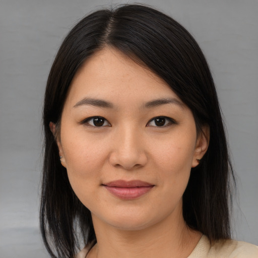 Joyful asian young-adult female with medium  brown hair and brown eyes