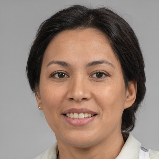 Joyful asian adult female with medium  brown hair and brown eyes