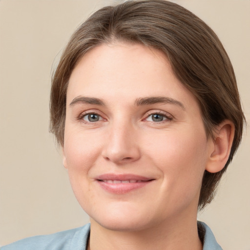 Joyful white young-adult female with medium  brown hair and grey eyes