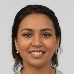 Joyful latino young-adult female with medium  brown hair and brown eyes