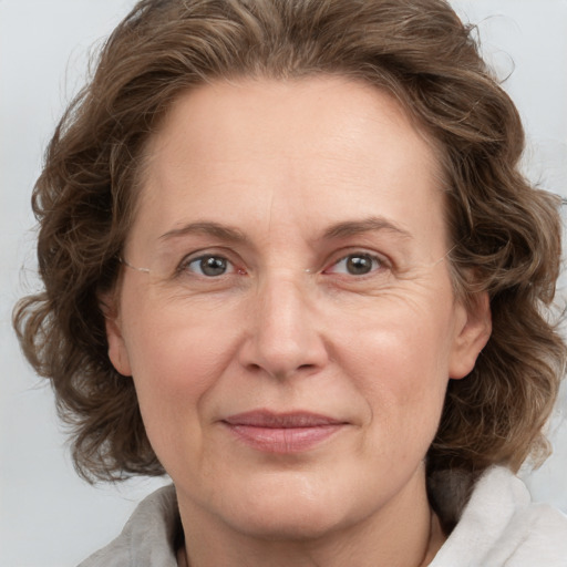 Joyful white adult female with medium  brown hair and grey eyes