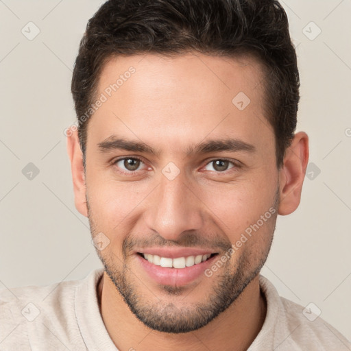 Joyful white young-adult male with short  brown hair and brown eyes