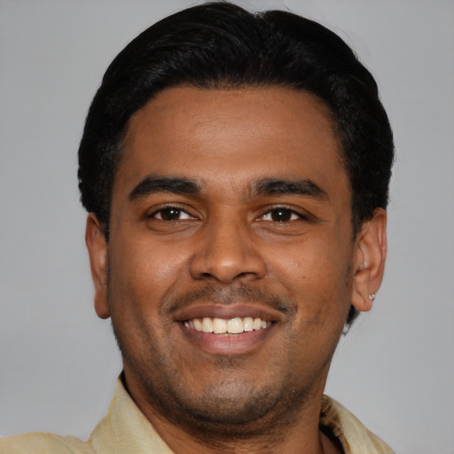Joyful latino young-adult male with short  black hair and brown eyes