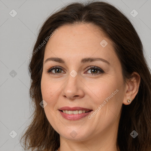 Joyful white adult female with long  brown hair and brown eyes