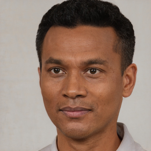 Joyful black young-adult male with short  black hair and brown eyes