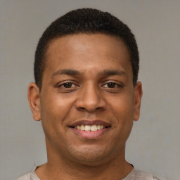 Joyful latino young-adult male with short  brown hair and brown eyes