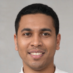 Joyful latino young-adult male with short  brown hair and brown eyes