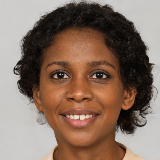 Joyful black young-adult female with short  brown hair and brown eyes