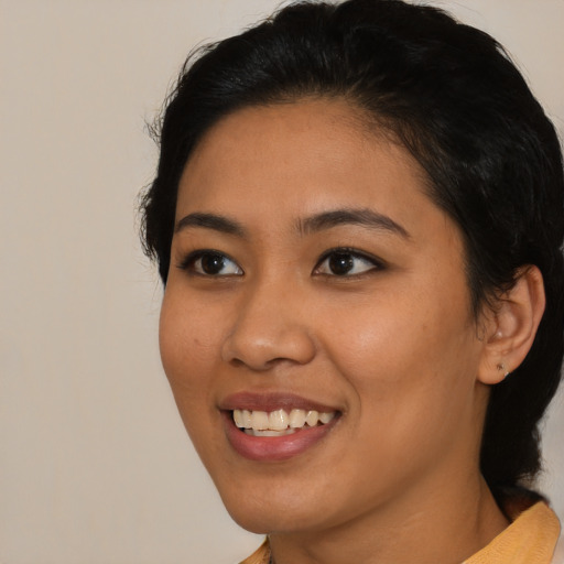 Joyful asian young-adult female with medium  black hair and brown eyes