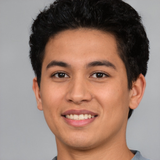 Joyful white young-adult male with short  black hair and brown eyes