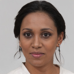 Joyful black adult female with medium  brown hair and brown eyes