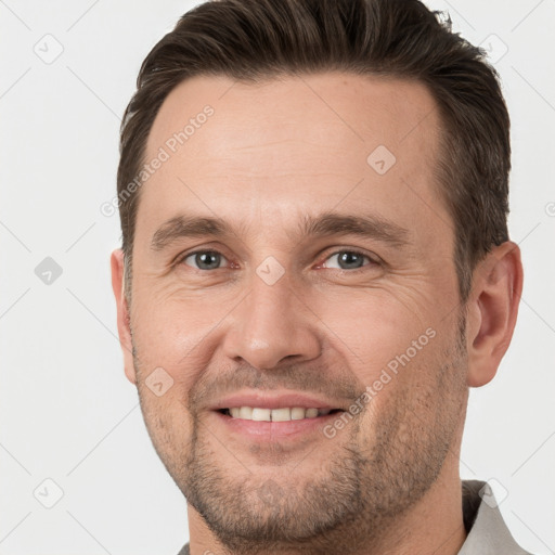 Joyful white adult male with short  brown hair and brown eyes