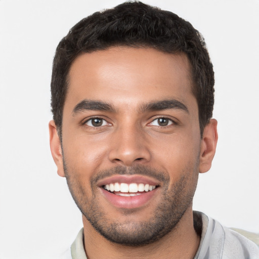 Joyful latino young-adult male with short  brown hair and brown eyes