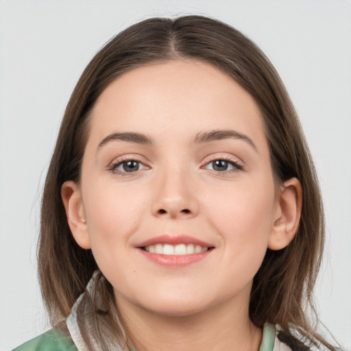 Joyful white young-adult female with medium  brown hair and grey eyes