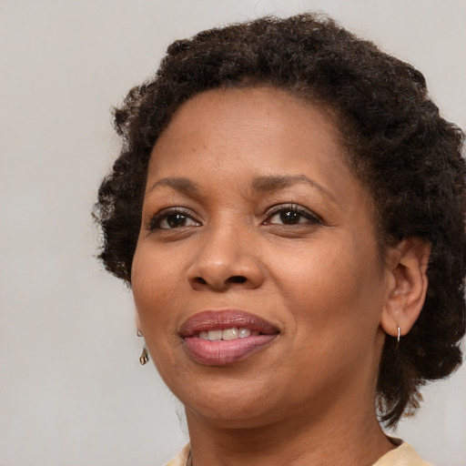 Joyful black adult female with medium  brown hair and brown eyes