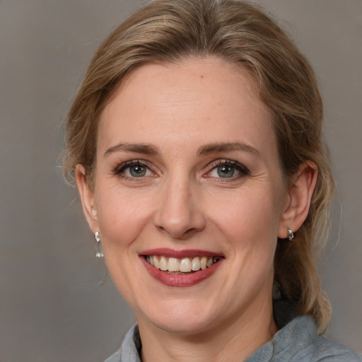 Joyful white adult female with medium  brown hair and grey eyes