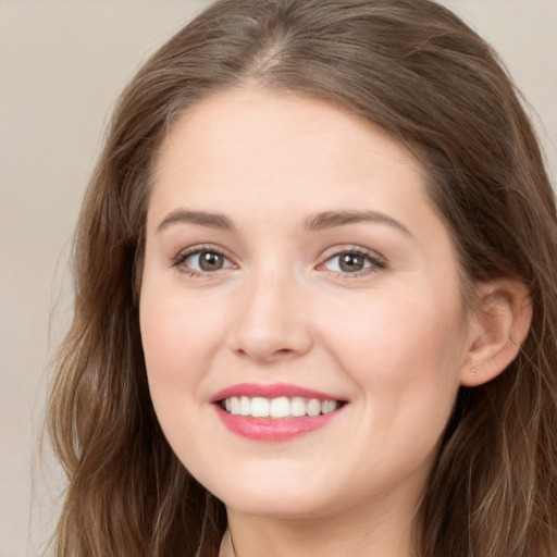 Joyful white young-adult female with long  brown hair and green eyes