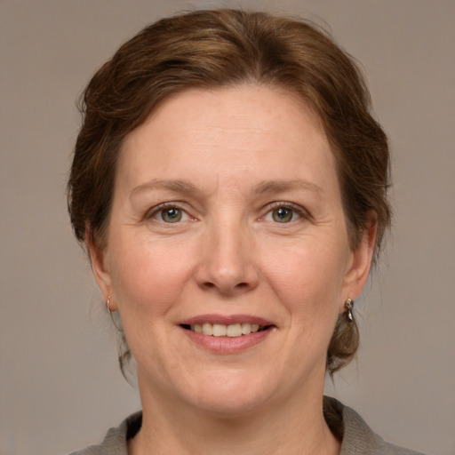 Joyful white adult female with medium  brown hair and grey eyes