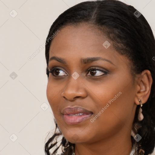 Joyful black young-adult female with long  black hair and brown eyes