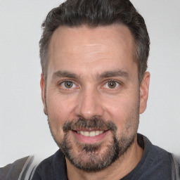 Joyful white adult male with short  brown hair and brown eyes