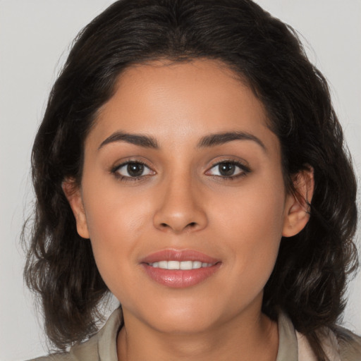 Joyful latino young-adult female with medium  brown hair and brown eyes