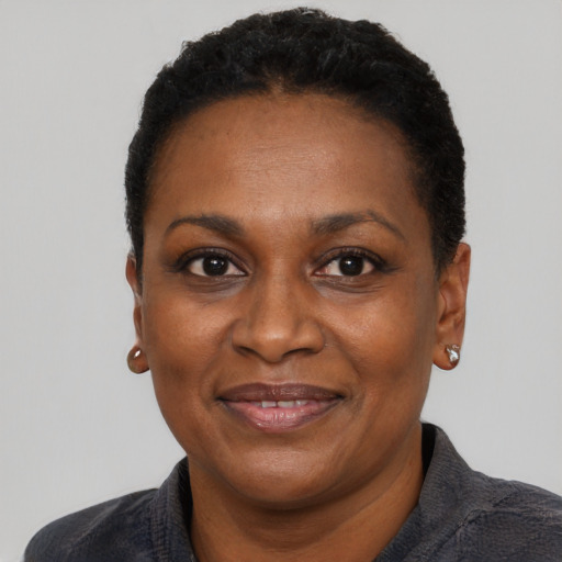 Joyful black adult female with short  black hair and brown eyes