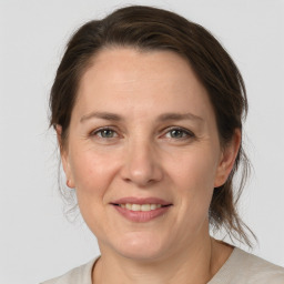 Joyful white adult female with medium  brown hair and grey eyes