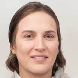 Joyful white young-adult female with medium  brown hair and grey eyes